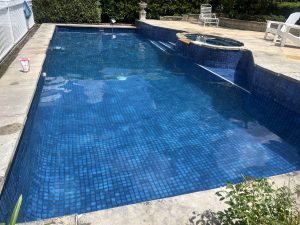 Swimming pool with dark blue tiles and clear